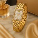 Relógio Feminino Berny Royale 2166L dourado em aço inoxidável, exibido em cenário premium sobre mármore com perfume e acessórios, estilo luxo RariElla.