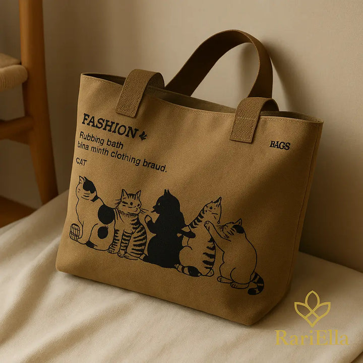 Bolsa tote khaki RariElla em canvas com estampa de gatos, fotografada em ambiente aconchegante com luz quente, estilo premium que destaca o produto.