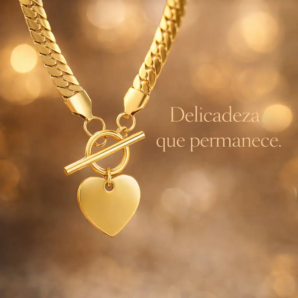 Colar dourado com pingente de coração em cenário sofisticado com luz quente (bokeh), destacando o brilho do aço inoxidável.