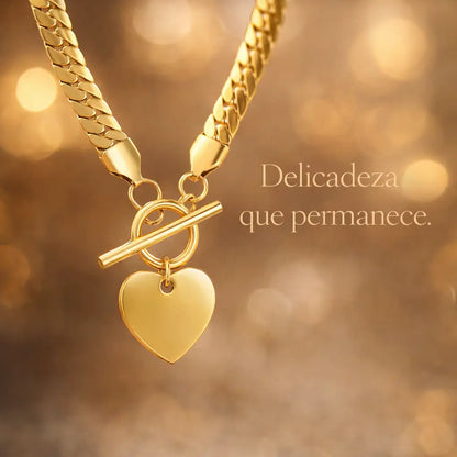 Colar dourado com pingente de coração em cenário sofisticado com luz quente (bokeh), destacando o brilho do aço inoxidável.