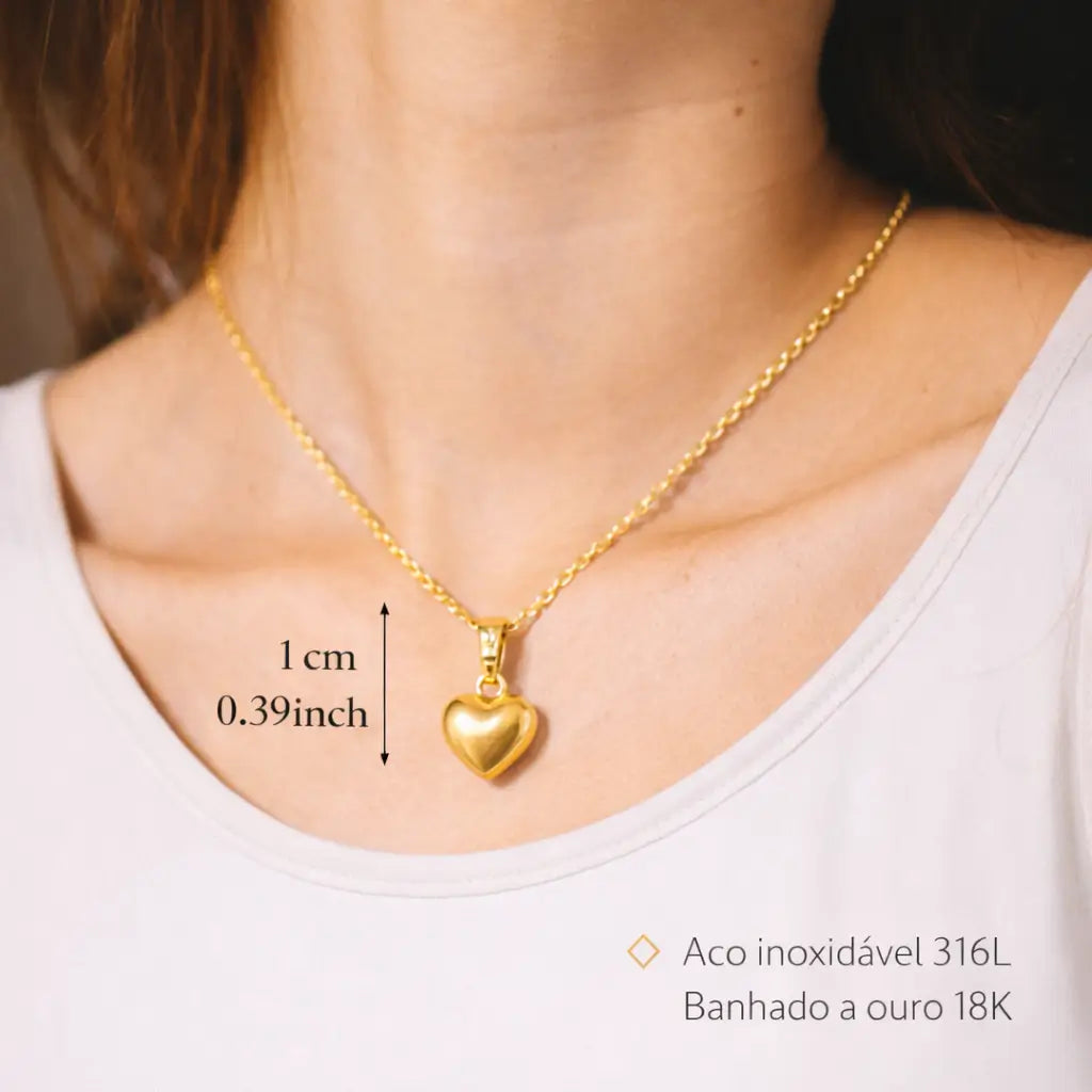 colar dourado 18k feminino com pingente coração mostrando tamanho e caimento no pescoço joia delicada