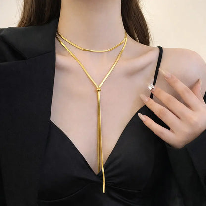 Colar Dourado Aura Linear™ em aço inoxidável ajustável sendo usado no pescoço feminino, design em Y com caimento elegante, moderno e alongador