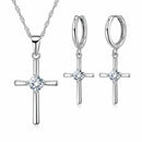 Conjunto Cruz Lumière em Prata 925 com zircônia cristal: colar com pingente de cruz e brincos de cruz em fundo branco.
