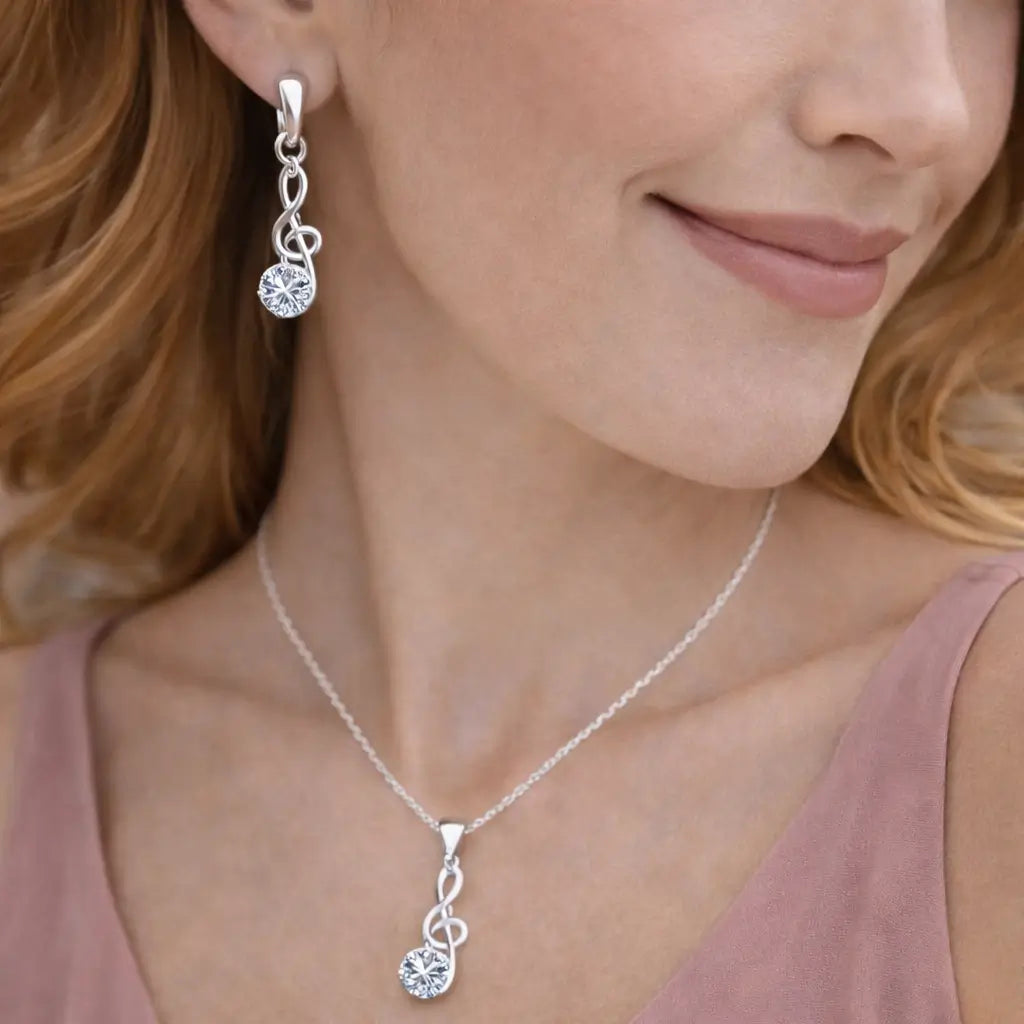 Close de mulher usando brincos e colar Harmonia Lumière em prata 925 com zircônia cúbica, joia delicada e sofisticada