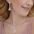 Close de mulher usando brincos e colar Harmonia Lumière em prata 925 com zircônia cúbica, joia delicada e sofisticada