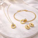 Modelo feminina usando o Conjunto Infinity Aurea dourado em aço inoxidável 18K com colar, pulseira e brincos elegantes