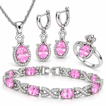 Conjunto Lumière prateado com pedras rosa mostrando colar, brincos, anel e pulseira