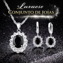 Mulher usando conjunto Noir Élégance em prata 925 com colar e brincos de pedra preta, joia elegante para ocasiões especiais.