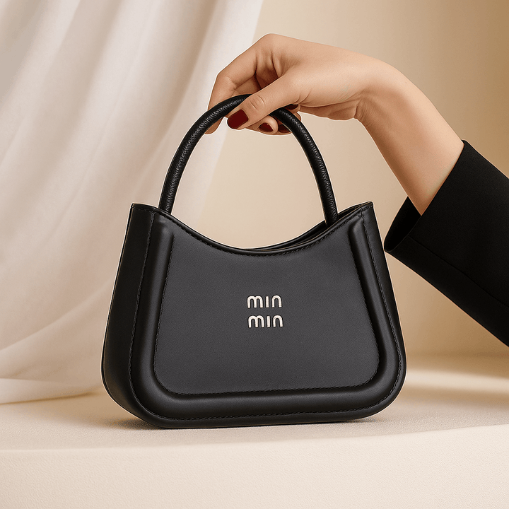 Bolsa Feminina Noir Luxe RariElla na cor preta, design minimalista premium com alça estruturada, exibida em cenário elegante — acessório moderno e sofisticado
